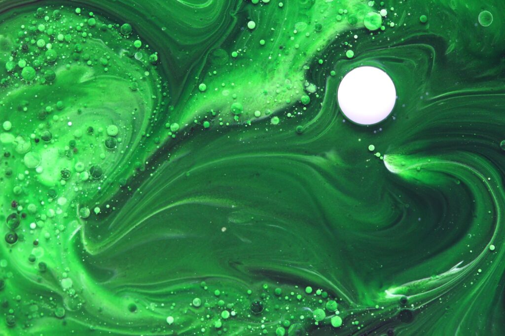 Mélange de différentes couleurs de peintures vertes. Il y a aussi des bulles et des ronds blancs.