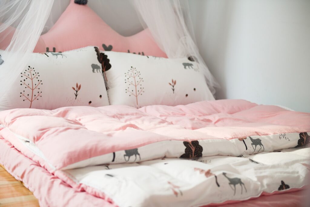 lit avec draps roses et chats