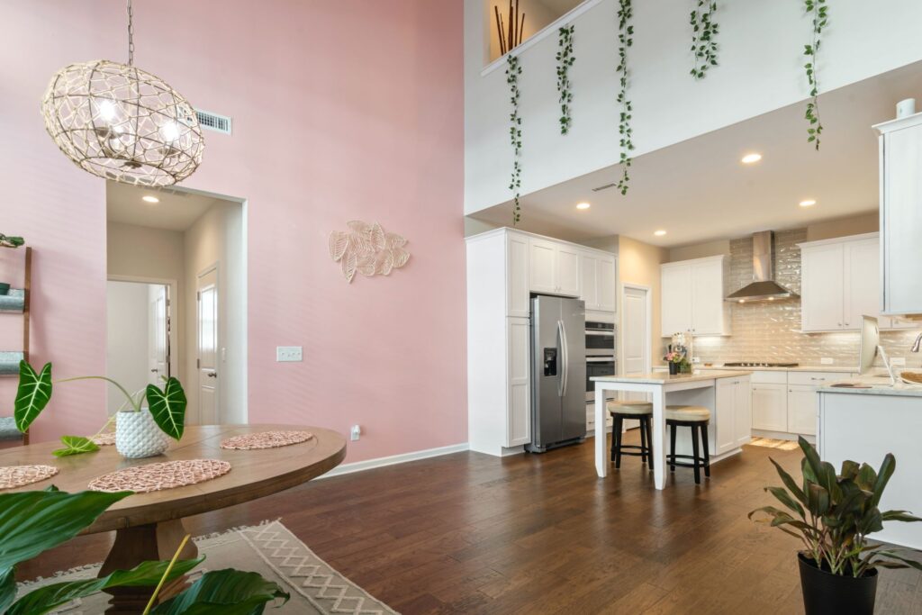 intérieur d'une habitation avec mur rose pastel et salon-cuisine moderne