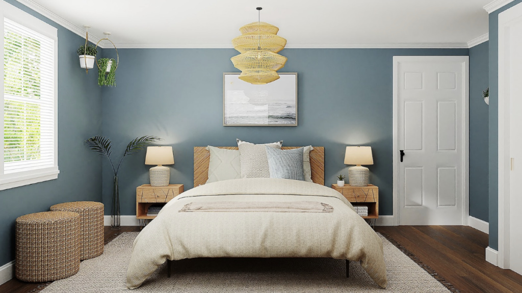 Grande chambre avec lit central et peinture bleu au niveau du mur de la tête de lit. La chambre est lumineuse et fonctionnelle