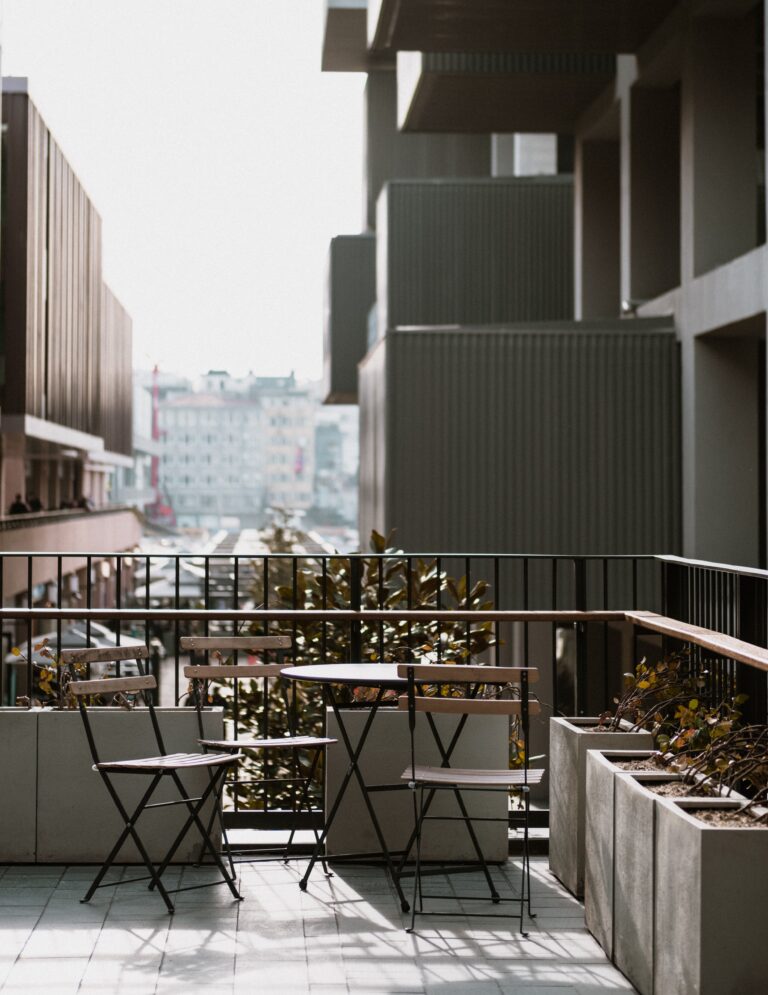 Balcon moderne avec salon de jardin en métal.