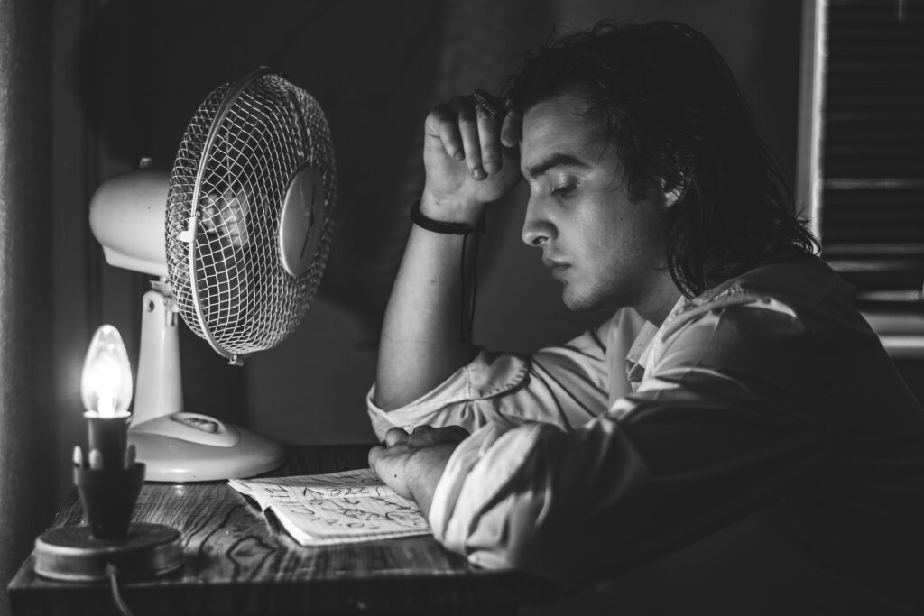 Homme lisant et profitant d'un ventilateur
