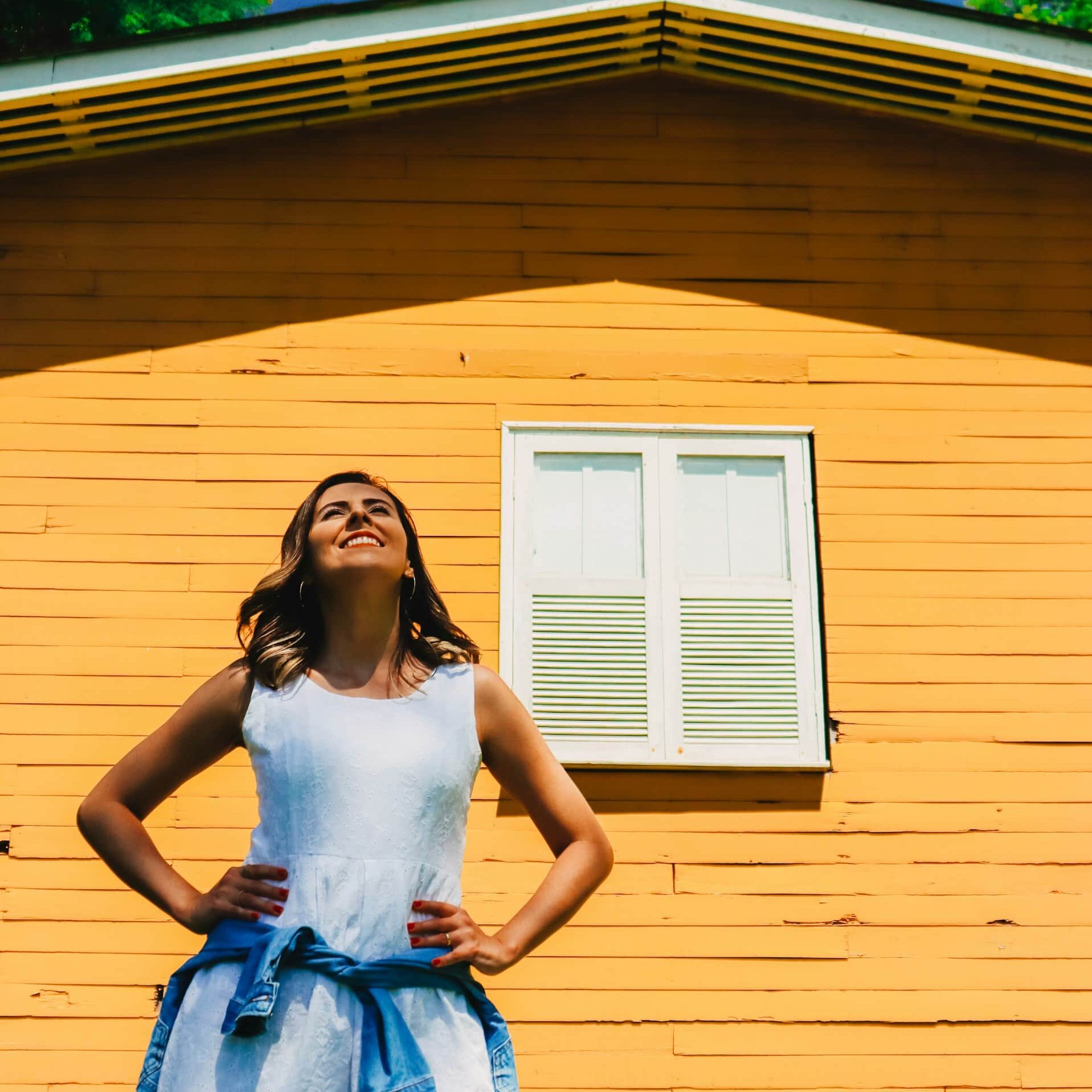 femme souriant devant maison neuve