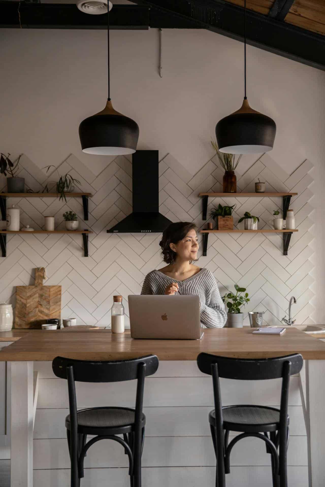 femme assise devant un ordinateur dans une cuisine extérieure