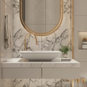 Salle de bain scandinave avec revêtement mural en carrelage marbré blanc. Le miroir est ovale et or, le lavabo est rond et blanc avec un robinet or.