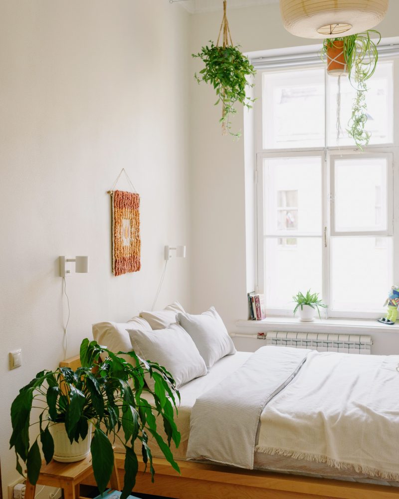 Chambre parentale moderne avec des plantes vertes.
