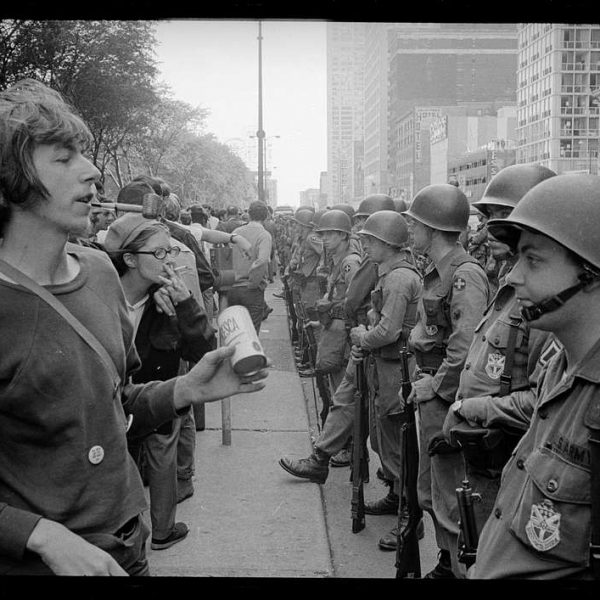 young-hippie-standing-in-front-of-a-row-of-national-guard-soldiers-across-the-b800cc-1024